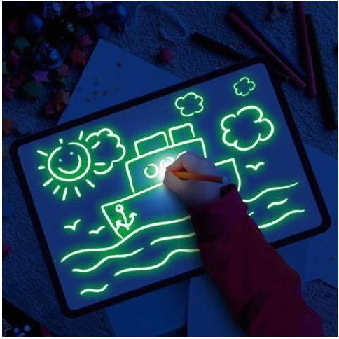 Child drawing glowing pictures on the light pad